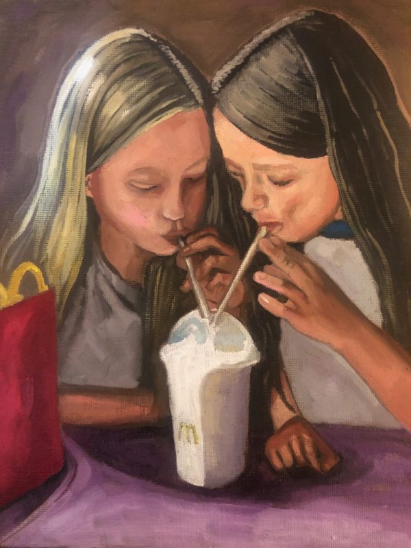 Portrait of two young girls drinking milkshake